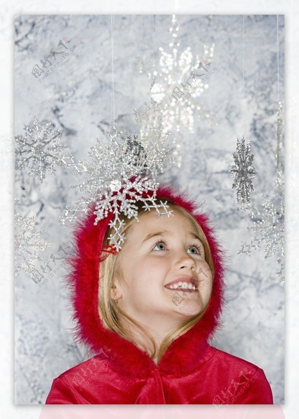 看圣诞雪花挂饰的甜蜜小女孩图片