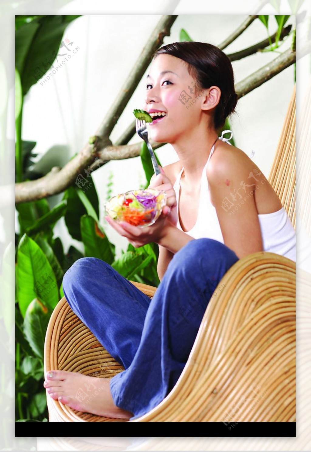 漂亮美女座藤椅微笑吃水果图片