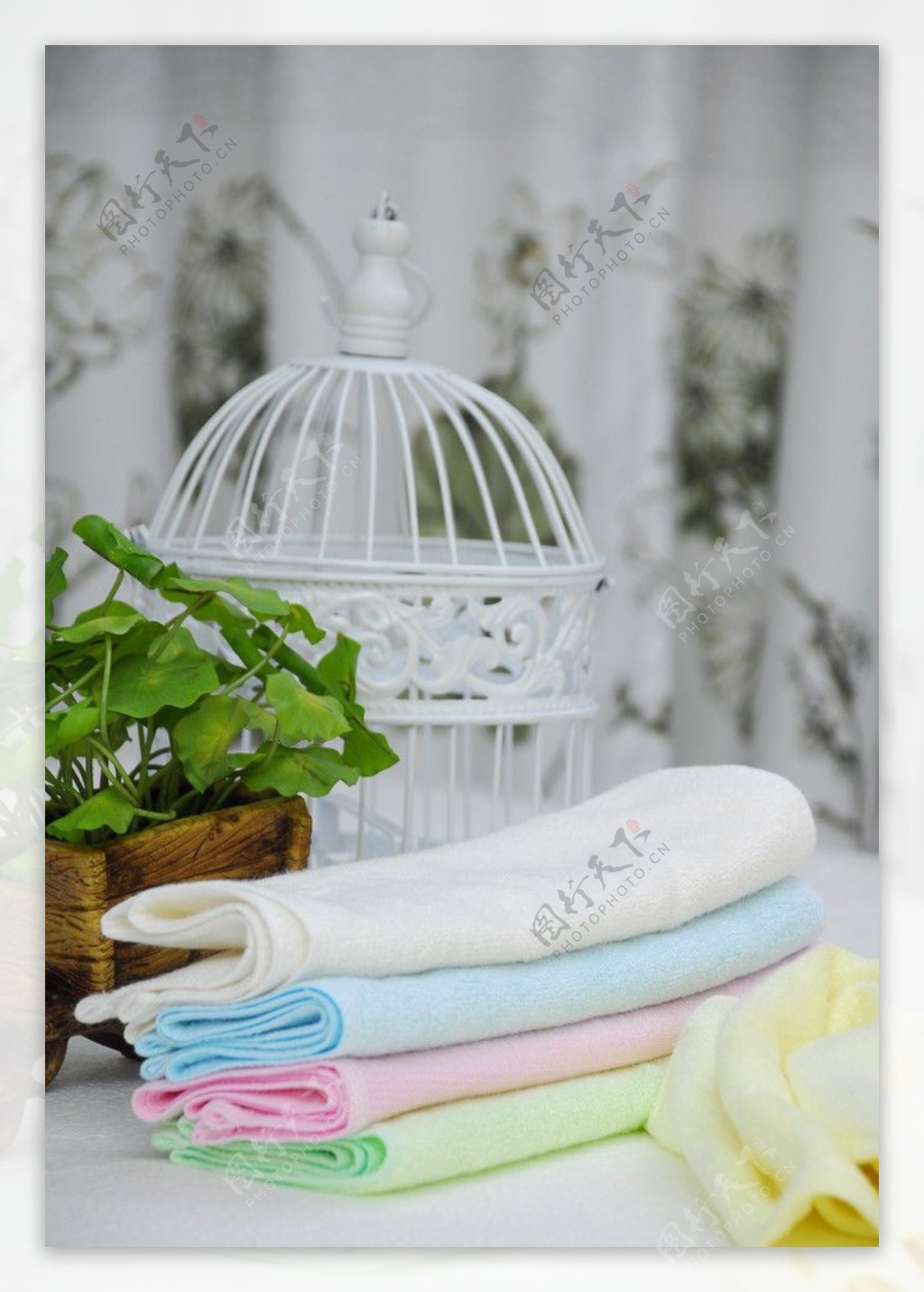 白色鸟笼前放着的彩色毛巾图片