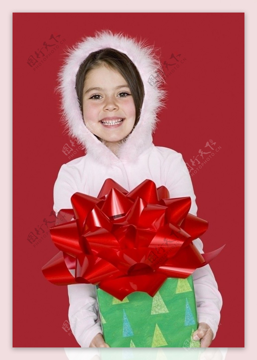 白色羽绒服抱着礼品盒的甜蜜小女孩图片
