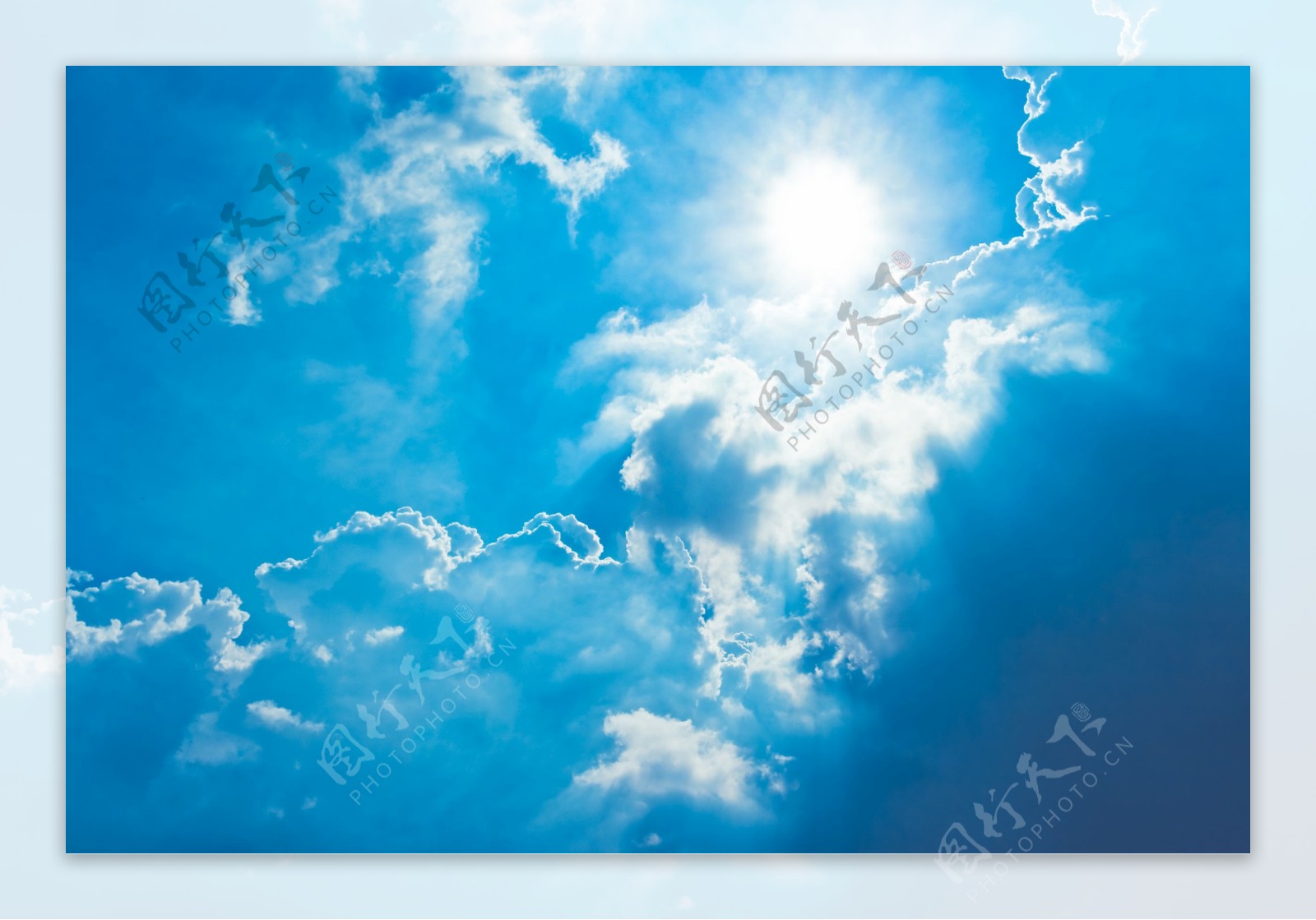 蓝天里透过白云漏出的阳光图片
