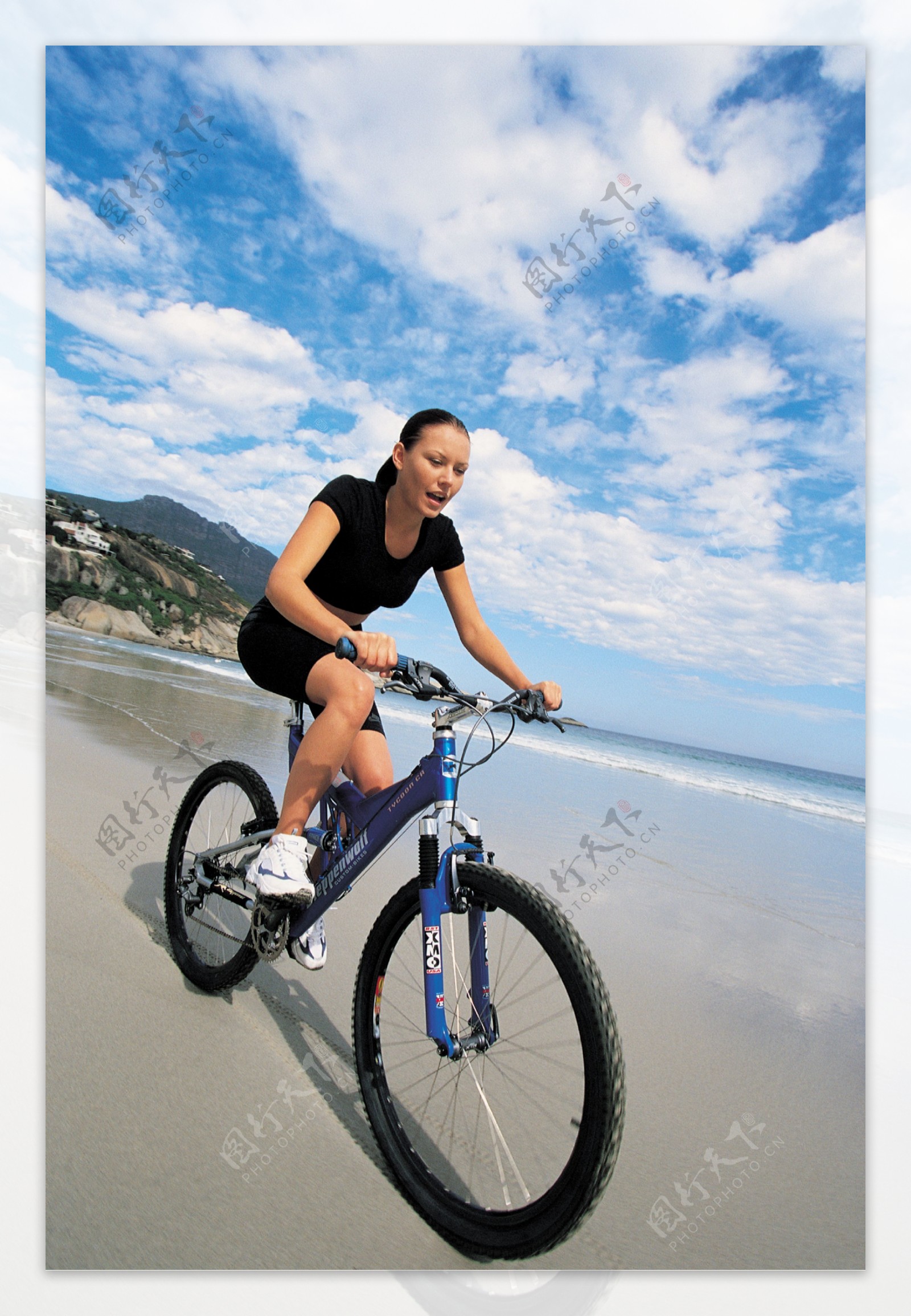 沙滩上骑自行车的美女图片