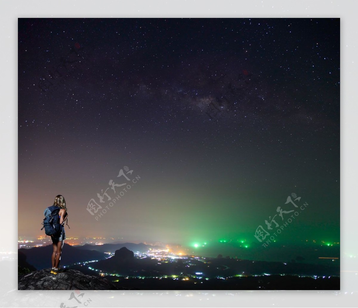 美丽的城市夜景和山地上的背包女图片