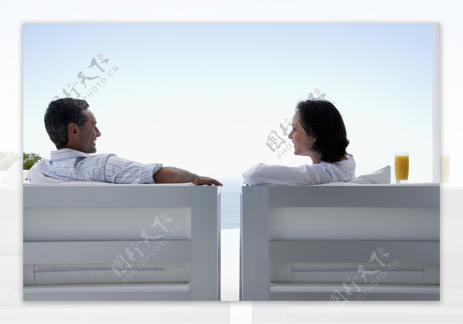 坐在海边休闲椅上的夫妇图片
