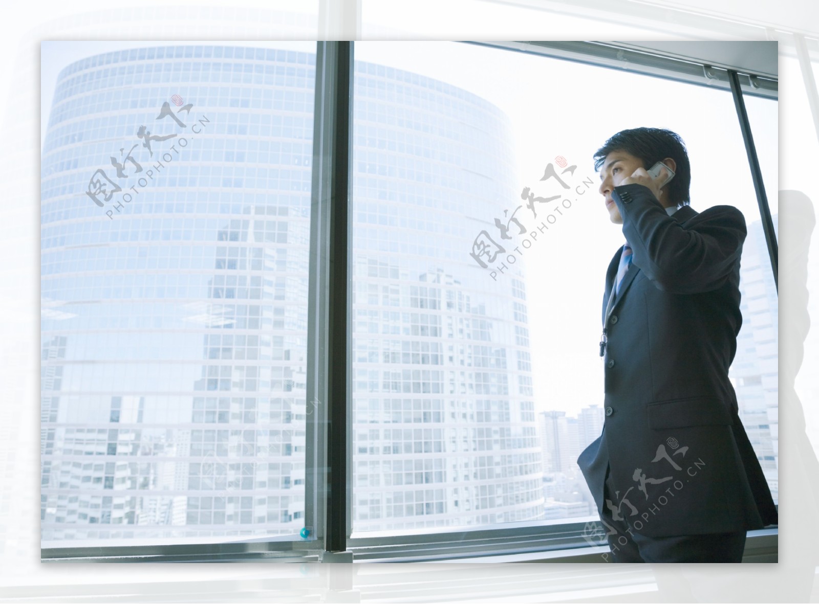 站在窗前打电话的商务男人图片