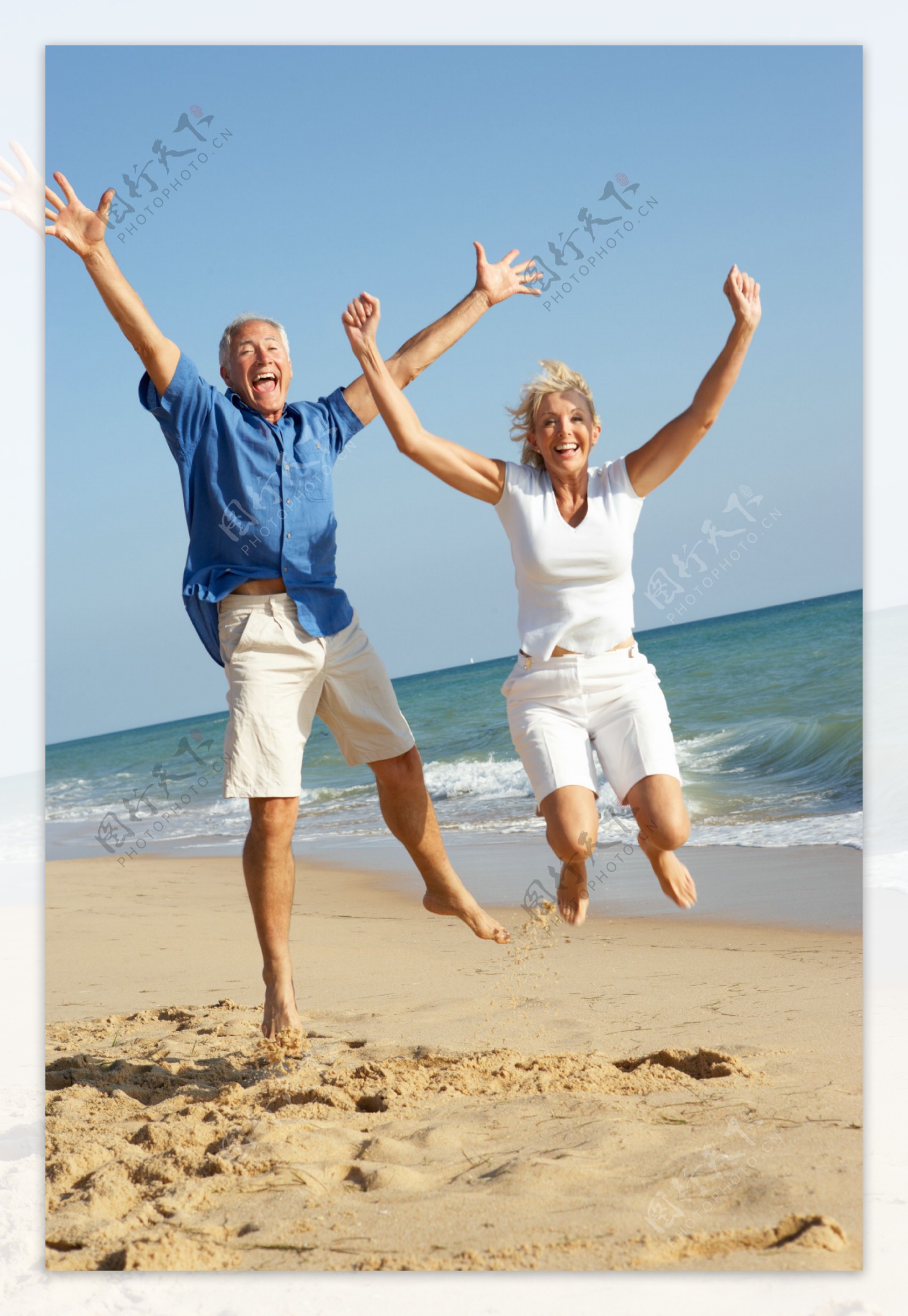 沙滩上的跳跃的老人夫妇图片