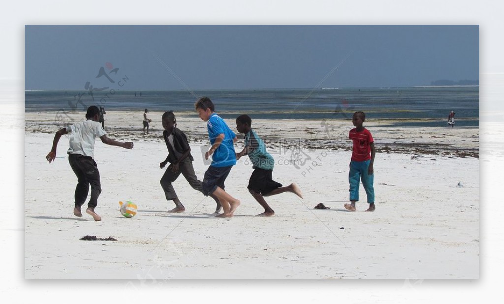 一群孩子在沙滩上踢足球