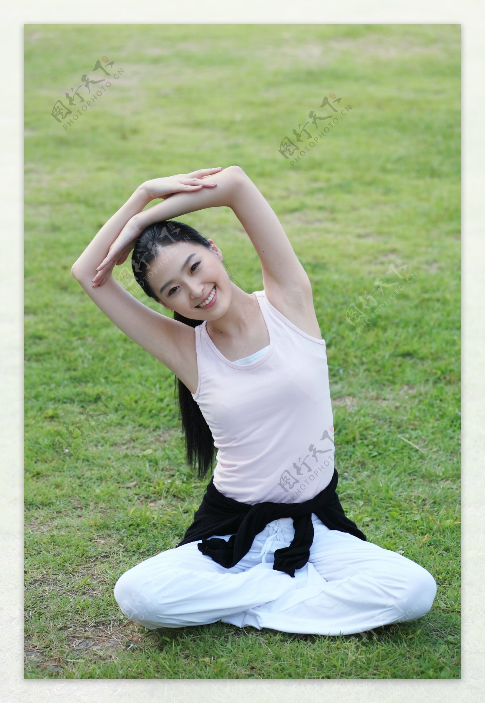 坐在草地上做瑜伽的运动少女图片图片