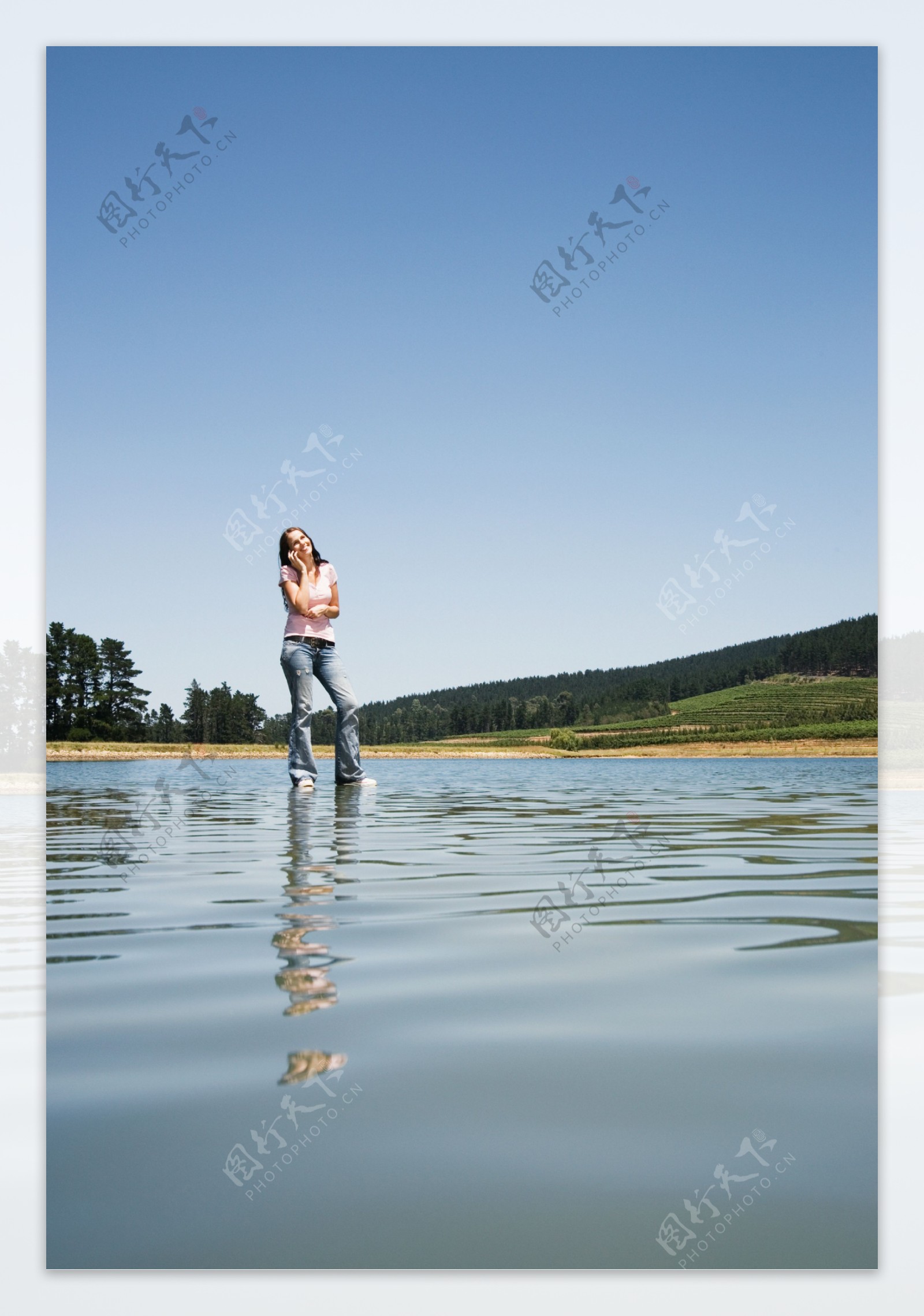 站立在水面打电话的女人图片