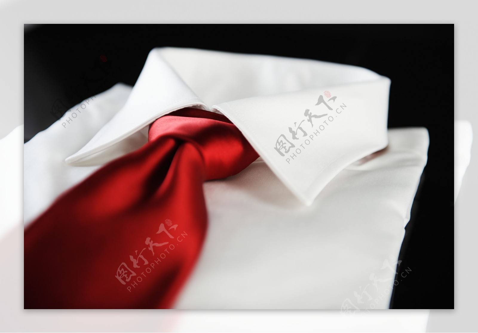 叠好的白色衬衫和红色领带图片
