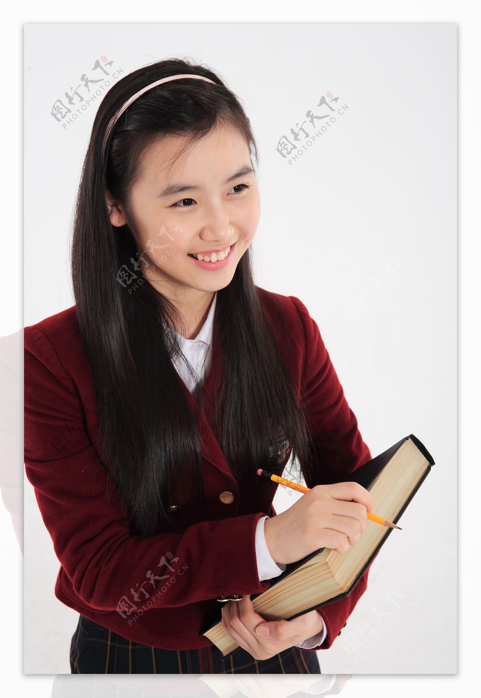 拿着铅笔抱着字典的漂亮女孩图片图片