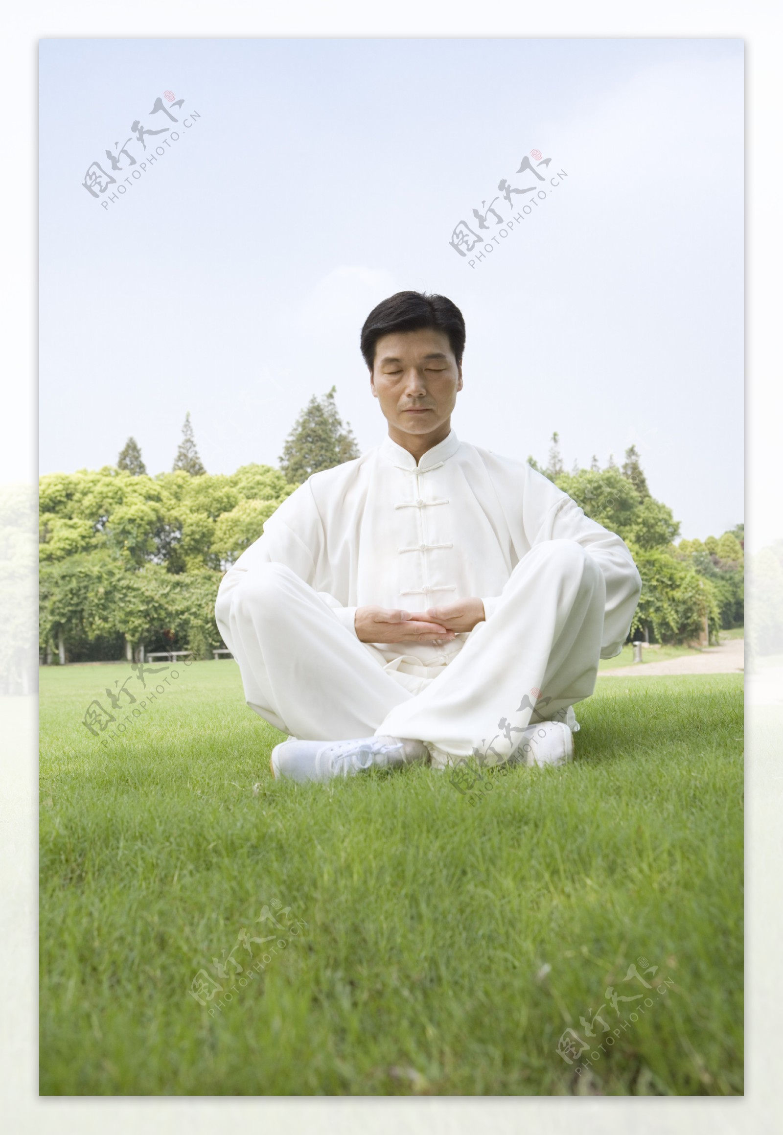 草地上打座的中年师傅图片图片