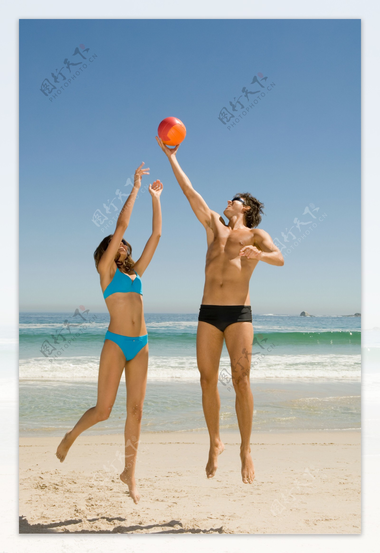 沙滩上玩球的情侣图片
