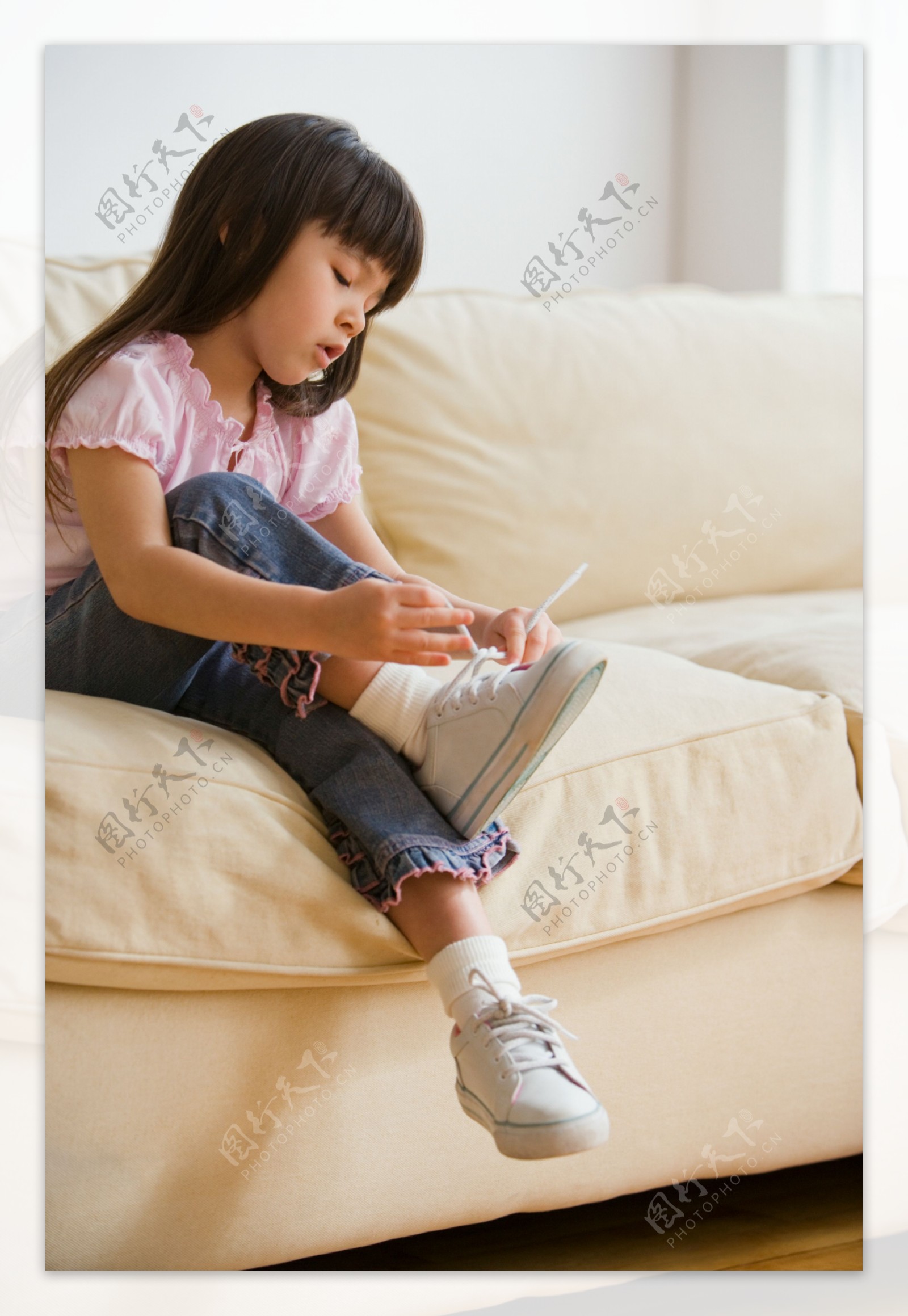 坐在沙发上绑鞋带的小女孩图片