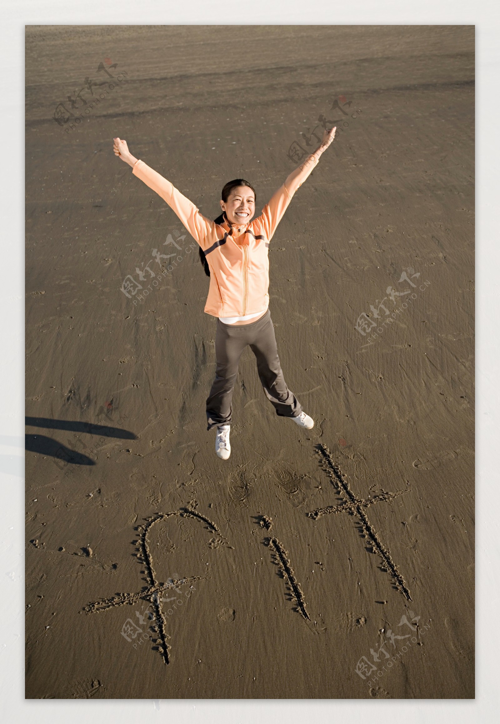 沙滩上跳跃的人物摄影图片
