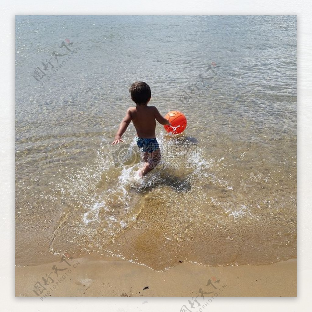 浅水滩玩球的小男孩