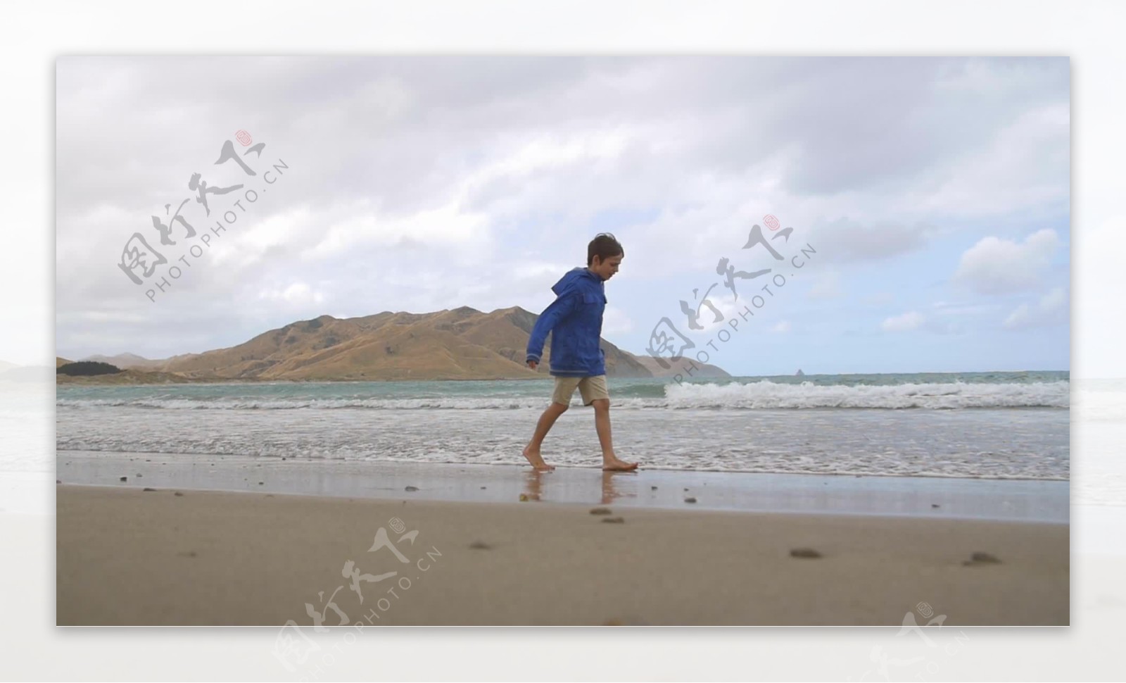 沿着风沙滩散步的小男孩