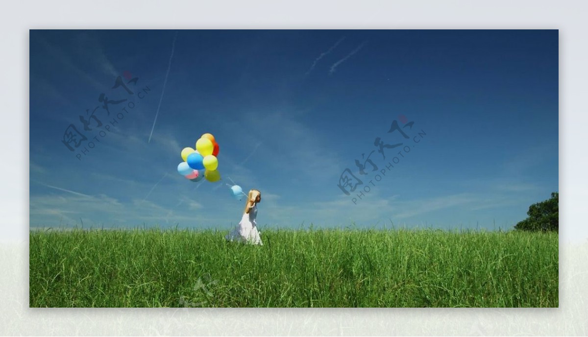 草地上小女孩拿气球跑过